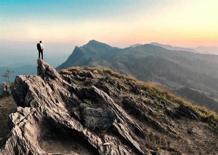 naem-2018-article-businessman-hike-on-peak-rocks-mountain-700x500